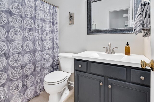 bathroom featuring toilet, vanity, tile patterned floors, a shower with curtain, and baseboards