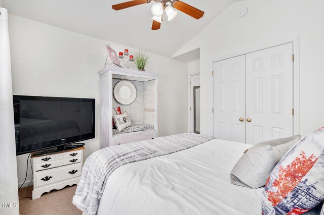 bedroom with vaulted ceiling, a closet, carpet flooring, and ceiling fan