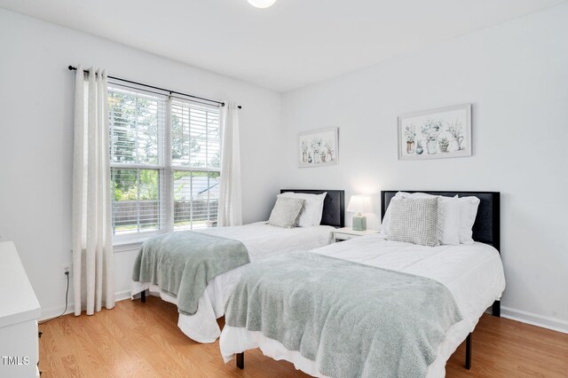 bedroom featuring wood finished floors and baseboards