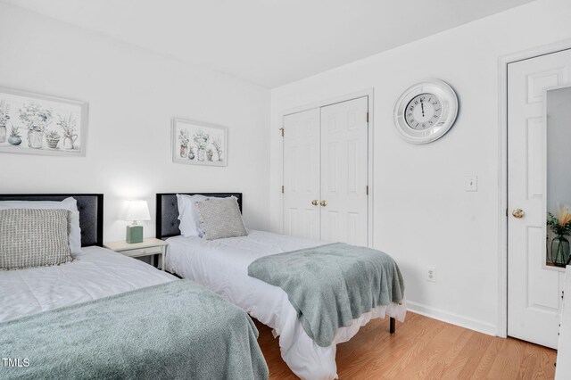 bedroom featuring light wood-style floors, a closet, and baseboards