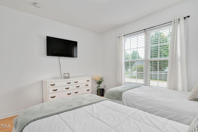 bedroom with light wood finished floors and baseboards