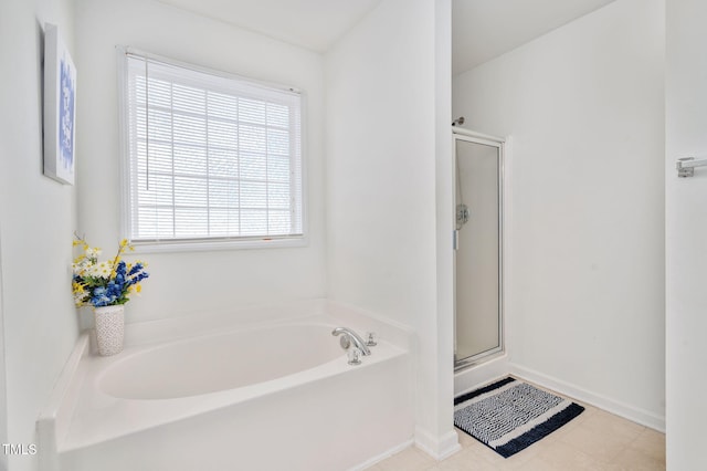 full bath with a stall shower, a garden tub, and baseboards