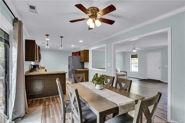 635 Chuckar Ct, Vass, NC 28394 - dining area with ceiling fan, ornamental molding, visible vents, and wood finished floors