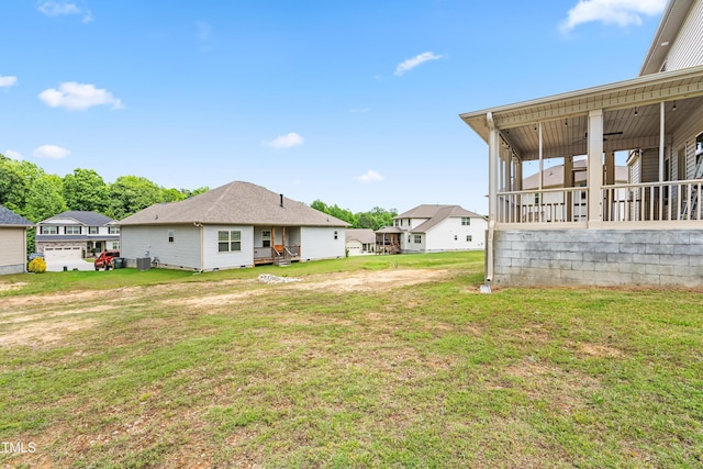 view of grassy yard with a sunroom and a residential view