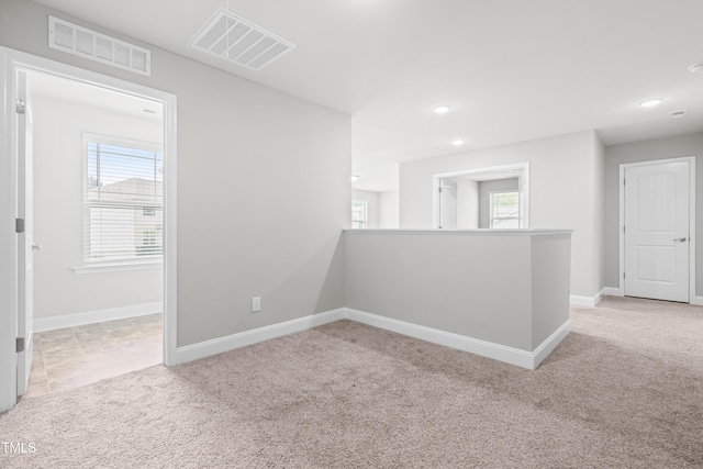 spare room with light colored carpet, recessed lighting, and baseboards