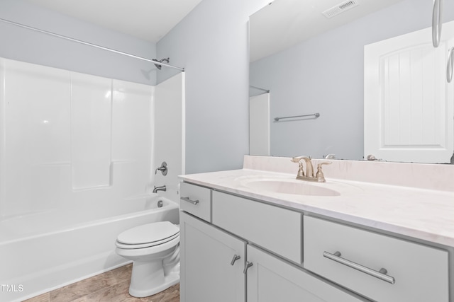 bathroom featuring toilet, vanity, and bathtub / shower combination