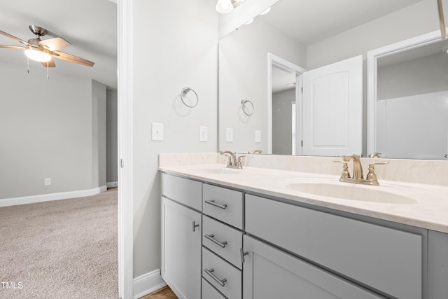 bathroom featuring baseboards, double vanity, and ceiling fan