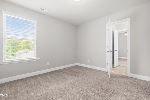 carpeted empty room featuring baseboards and ceiling fan