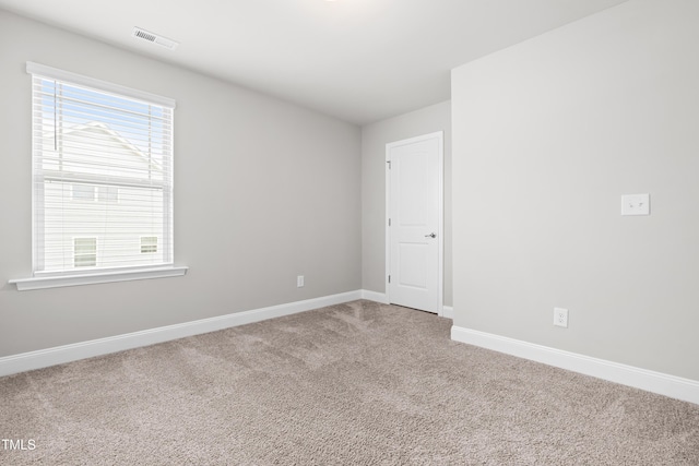 empty room featuring carpet and baseboards