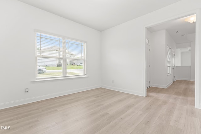 spare room with light wood finished floors and baseboards