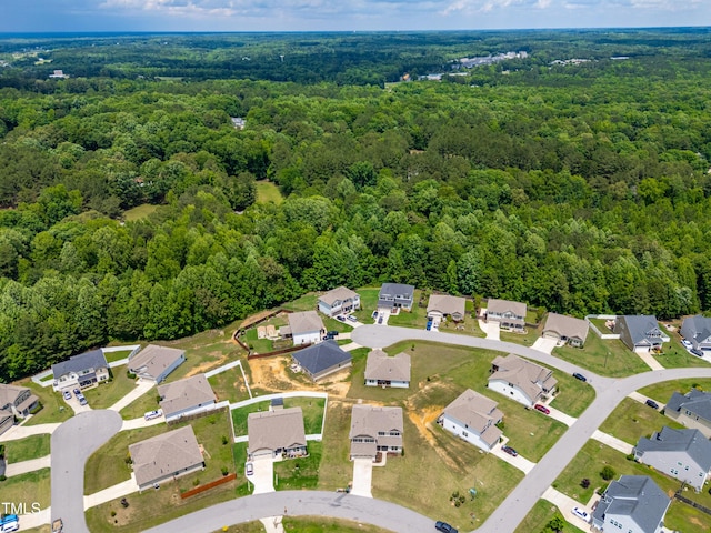 aerial view of property's location featuring a heavily wooded area and nearby suburban area