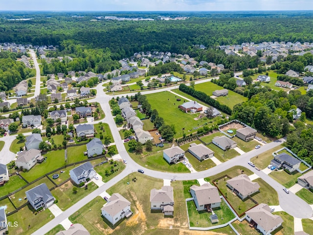 view of property location with a forest and nearby suburban area