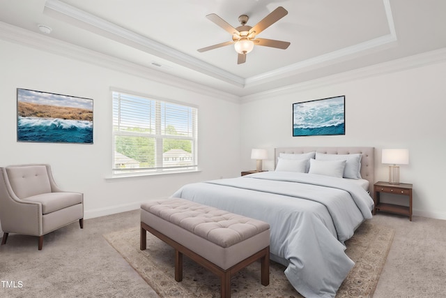 bedroom featuring a tray ceiling, crown molding, light colored carpet, baseboards, and ceiling fan