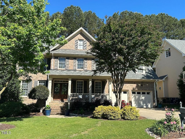 view of front of property with a porch, concrete driveway, a front lawn, and brick siding