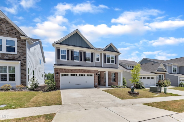 2100 Curry Meadow Way, Durham, NC 27703 - view of front of home with board and batten siding, driveway, a front lawn, brick siding, and a garage