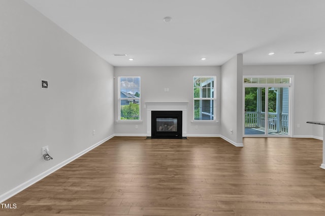 2100 Curry Meadow Way, Durham, NC 27703 - unfurnished living room featuring a fireplace with flush hearth, wood finished floors, baseboards, and recessed lighting