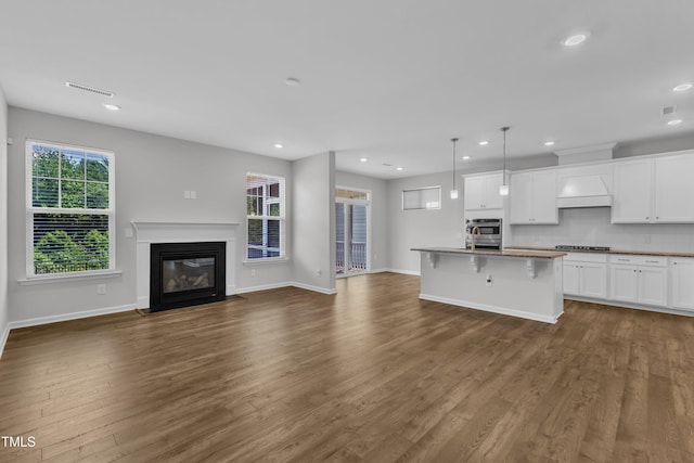 2100 Curry Meadow Way, Durham, NC 27703 - kitchen featuring open floor plan, recessed lighting, dark wood-type flooring, a kitchen bar, and white cabinets