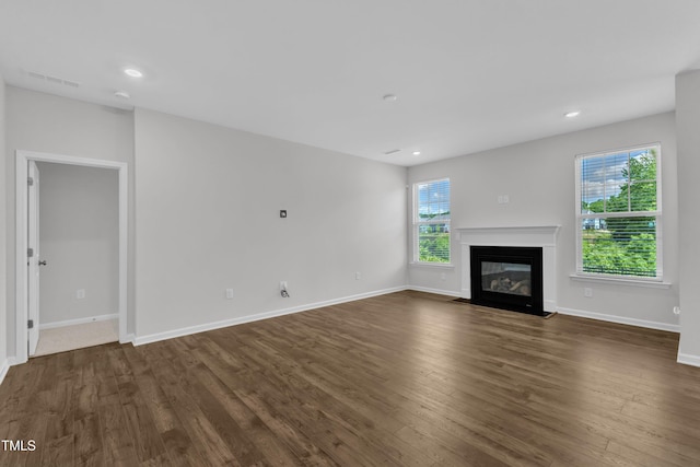 2100 Curry Meadow Way, Durham, NC 27703 - unfurnished living room featuring dark wood-style floors, baseboards, a fireplace with flush hearth, and recessed lighting