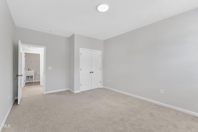 2100 Curry Meadow Way, Durham, NC 27703 - unfurnished bedroom with light colored carpet, baseboards, and a closet