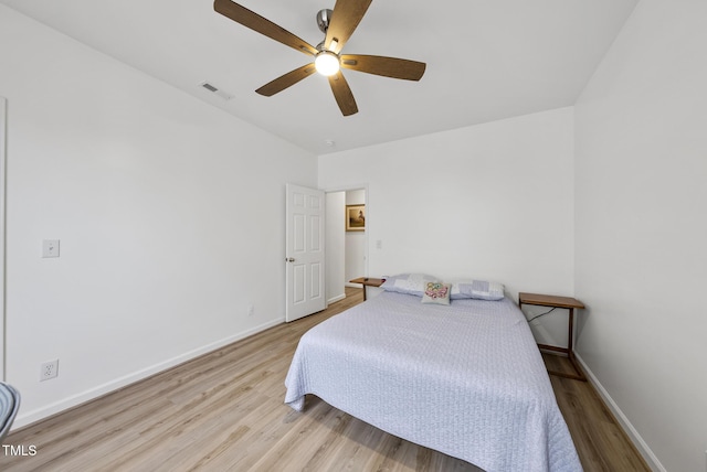 bedroom featuring wood finished floors, baseboards, and a ceiling fan