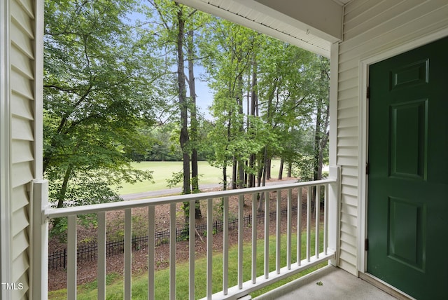 balcony featuring view of scattered trees