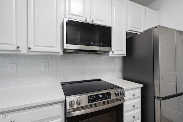 kitchen with stainless steel appliances, light countertops, white cabinets, and tasteful backsplash