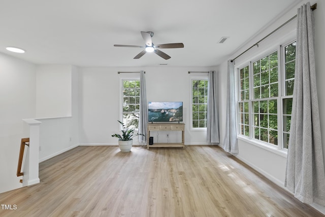 unfurnished living room with a ceiling fan, wood finished floors, and baseboards