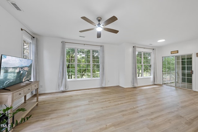 unfurnished living room featuring healthy amount of natural light, ceiling fan, and light wood-style floors