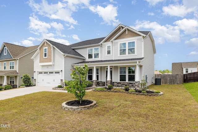 craftsman-style house with driveway, fence, an attached garage, stone siding, and a porch