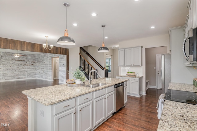 kitchen featuring a sink, a kitchen island with sink, dark wood-type flooring, and appliances with stainless steel finishes