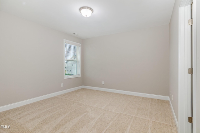 carpeted spare room featuring baseboards and visible vents
