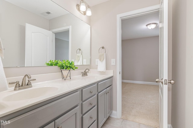 bathroom with a sink, double vanity, baseboards, and visible vents