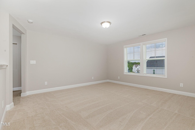 unfurnished room with baseboards, visible vents, and light colored carpet
