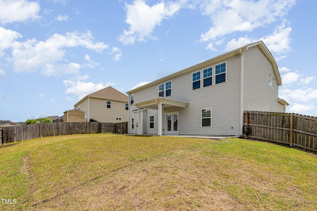 back of house featuring a fenced backyard, french doors, and a yard
