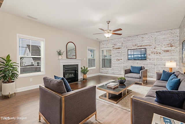 159 Gladstone St, Raeford, NC 28376 - living room featuring a glass covered fireplace, a ceiling fan, wood finished floors, and baseboards