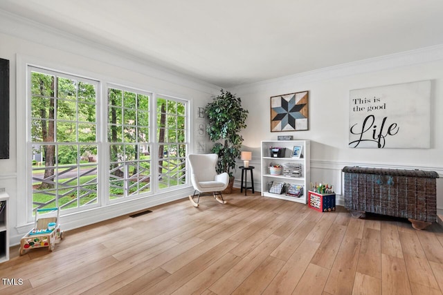 sitting room featuring wood finished floors and ornamental molding