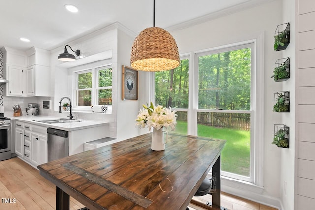 dining space with ornamental molding, light wood-style flooring, and recessed lighting