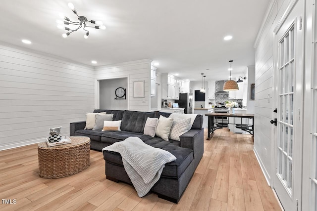 living room featuring light wood finished floors, a chandelier, recessed lighting, and baseboards