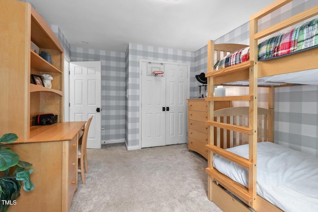 carpeted bedroom featuring wallpapered walls and a closet