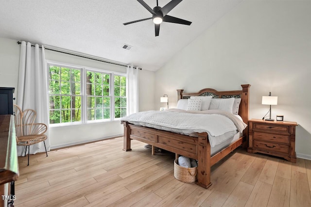 bedroom featuring lofted ceiling, light wood-style floors, ceiling fan, and baseboards