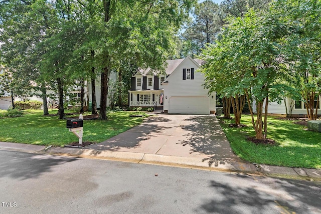 obstructed view of property featuring a garage, driveway, and a front lawn