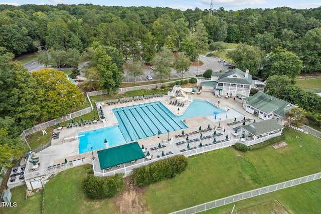 aerial view of property and surrounding area with a pool area and a forest
