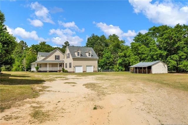 view of front of property with an outbuilding, dirt driveway, a pole building, an attached garage, and a front yard