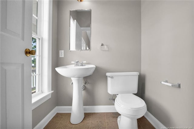 bathroom with tile patterned floors, toilet, and baseboards