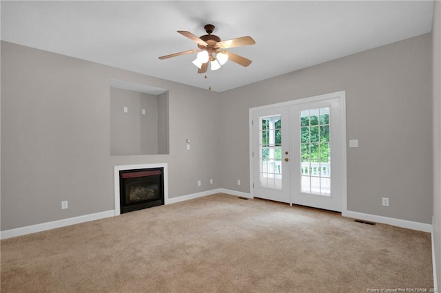 unfurnished living room featuring carpet flooring, french doors, visible vents, baseboards, and ceiling fan