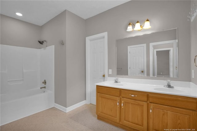 full bath featuring double vanity, shower / bathtub combination, baseboards, and a sink