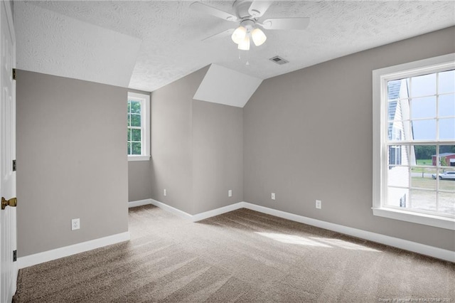 bonus room with a textured ceiling, visible vents, ceiling fan, carpet floors, and baseboards