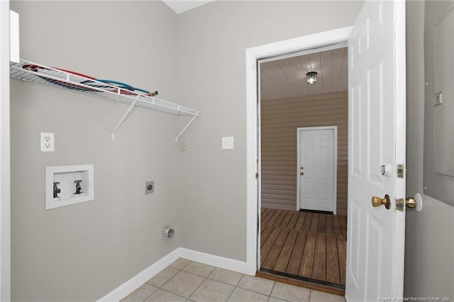 laundry room with laundry area, hookup for an electric dryer, light tile patterned floors, washer hookup, and baseboards