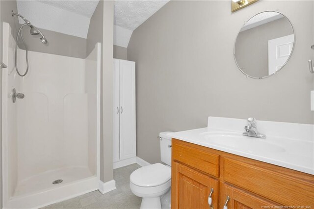 bathroom featuring toilet, vanity, tile patterned flooring, a shower stall, and baseboards