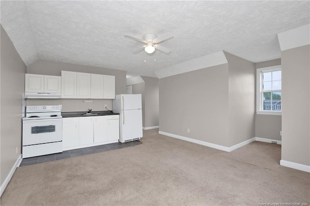 kitchen featuring under cabinet range hood, dark colored carpet, a ceiling fan, and white appliances